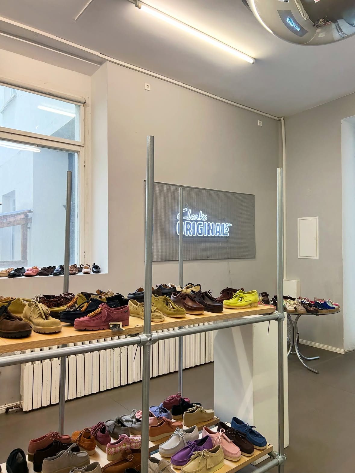 The café room set up with shoes on shelves and a Clarks Originals neon